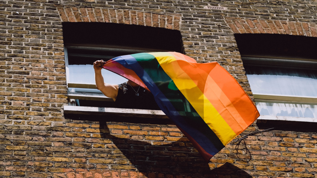 Iemand die de regenboogvlag uithangt