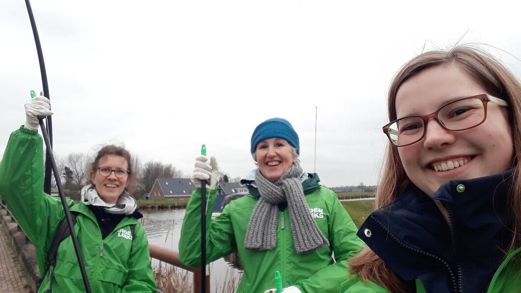 3 GroenLinksers met prikstokken in hun handen